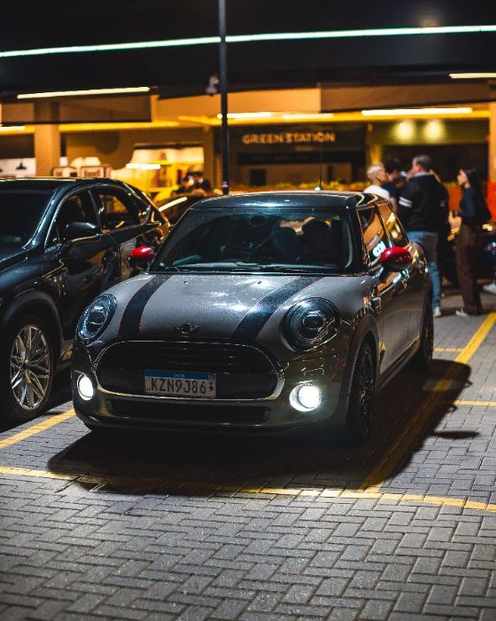 Mini Cooper preto com faróis acesos